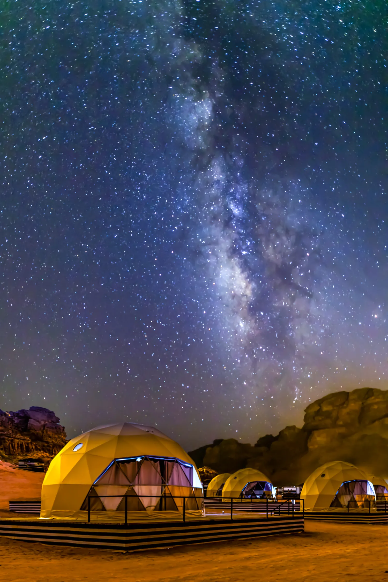 Illuminated desert tent beneath the Milky Way in Wadi Rum, Jordan