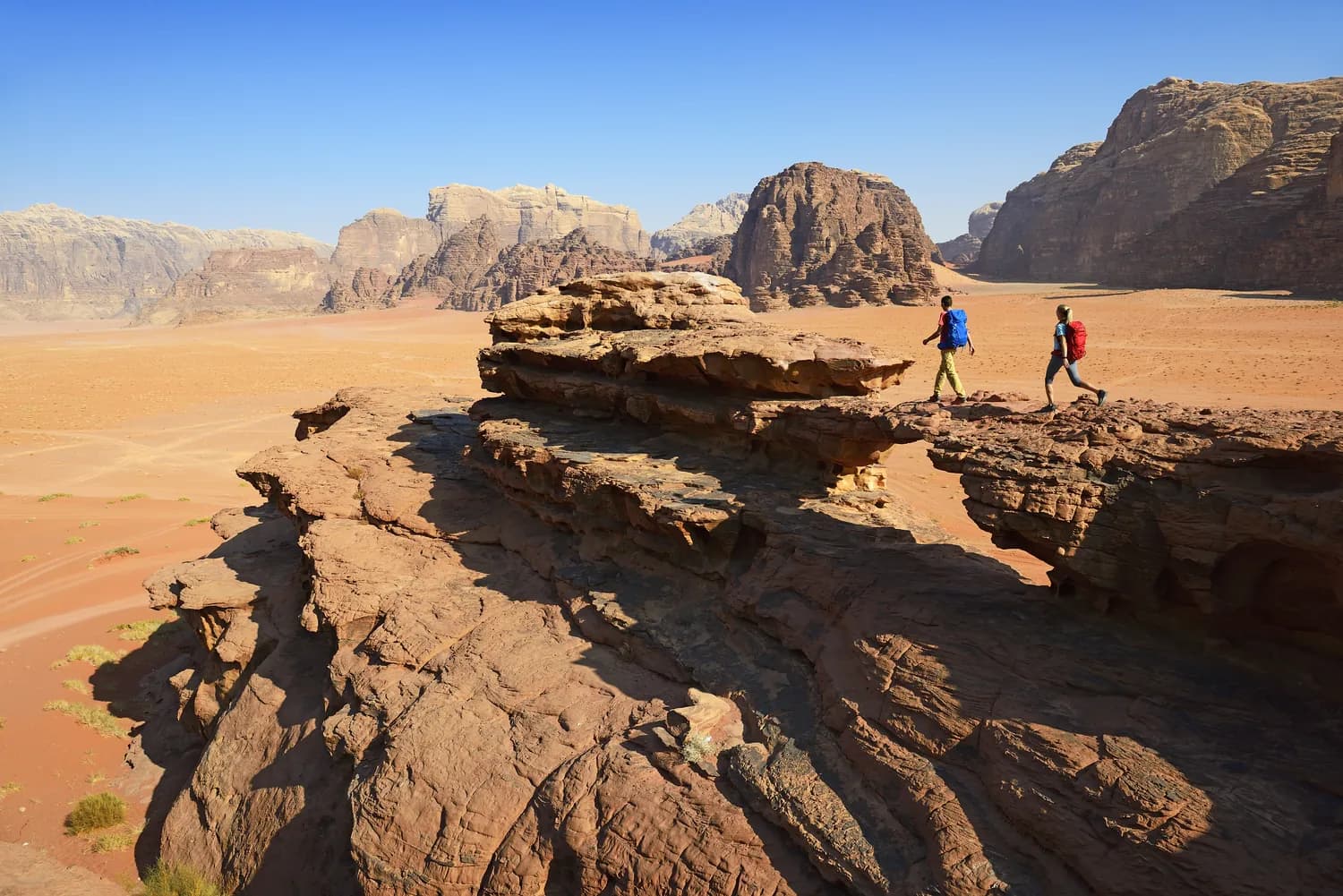 Travelers hiking among rock formations in Wadi Rum, Jordan