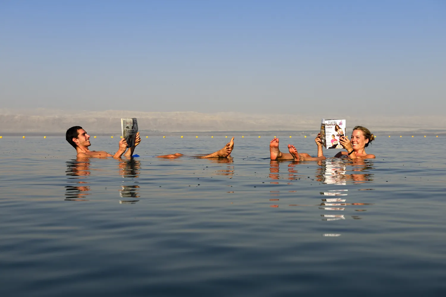 Visitors floating in the mineral-rich water of the Dead Sea in Jordan