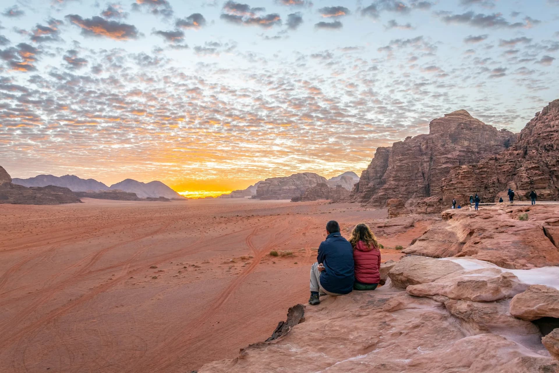 Travelers watching sunset across the desert in Wadi Rum, Jordan